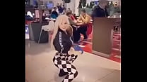 preciosa rubia bailando en el centro comercial