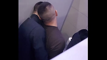 2 men having fun in a public toilet